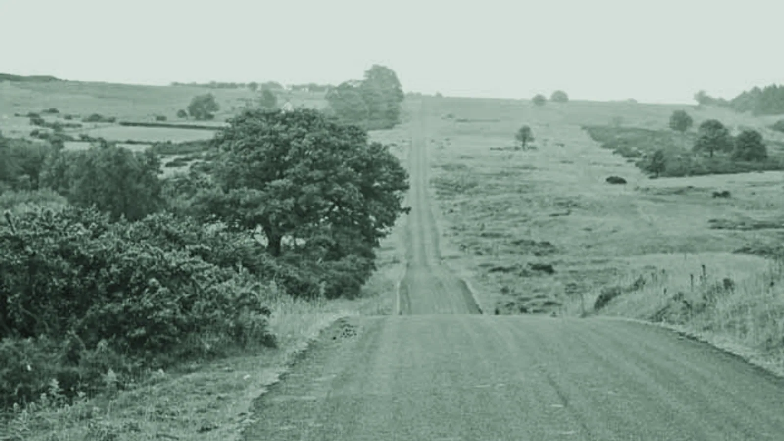 A narrow switchback road crossing open countryside.